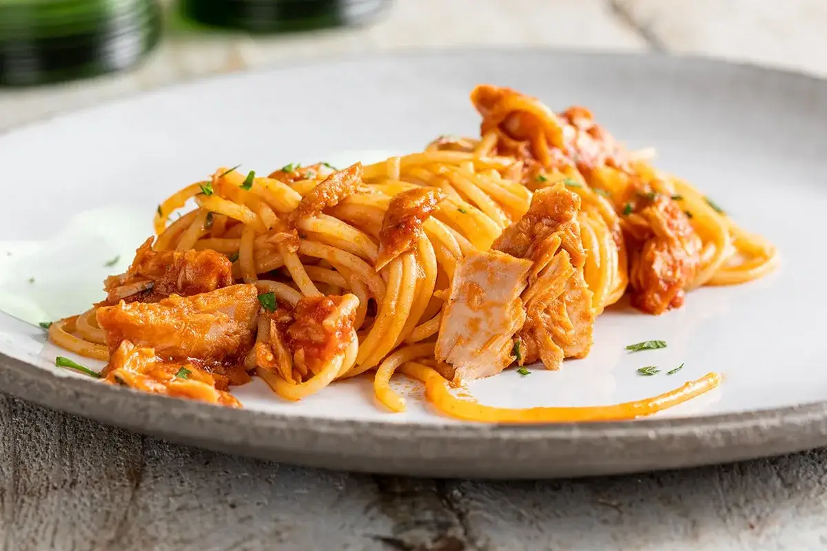 Un piatto invitante di pasta al tonno, con spaghetti conditi con un sugo saporito e generosi pezzi di tonno.