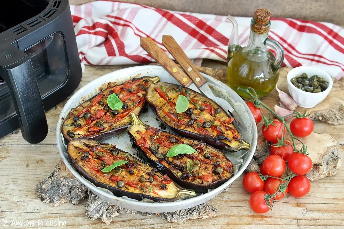 Melanzane grigliate in friggitrice ad aria, condite con pomodorini, capperi e basilico. Un piatto saporito e leggero.
