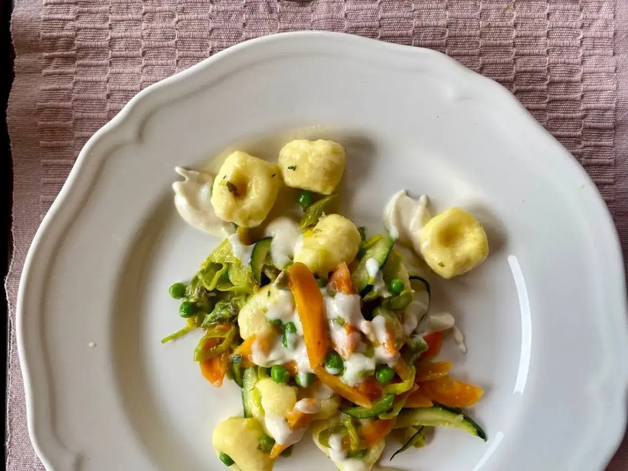 Gnocchi di ricotta soffici con verdure primaverili e una delicata salsa cremosa.