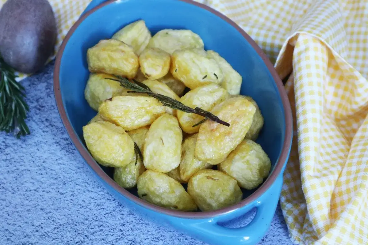 Patate novelle dorate e croccanti, appena sfornate dalla friggitrice ad aria, guarnite con rosmarino fresco.