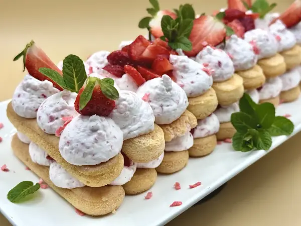 Delizioso tiramisù alle fragole, un tripudio di savoiardi, crema soffice e fragole fresche, decorato con menta.