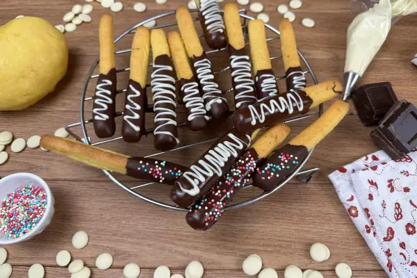 Biscotti al cioccolato decorati con glassa bianca e zuccherini colorati, pronti per essere gustati.