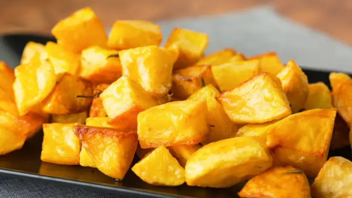 Un piatto invitante di patate al forno dorate e croccanti, perfette per accompagnare ogni pasto.